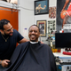 Barber Eric Muhammad, owner of A New You Barbershop, jokes with regular customer Marc M. Sims before measuring his blood pressure in Inglewood, Calif., on March 11, 2018.